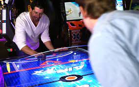 Two men playing ice hickey at an arcade